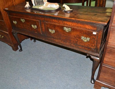 Lot 720 - An 18th century oak open dresser base with two drawers, raised on cabriole legs with pad feet