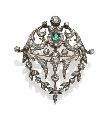 Lot 474 - A Late Victorian Emerald and Diamond Brooch, a cushion shaped emerald within a scrolling...