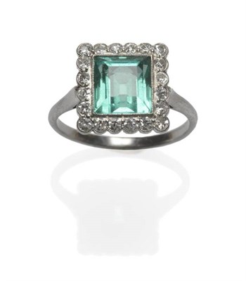 Lot 483 - An Emerald and Diamond Cluster Ring, circa 1930, the almost square light green step cut emerald...