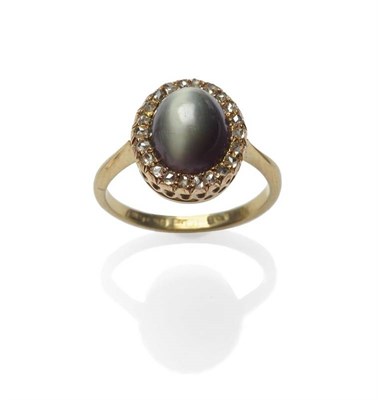 Lot 496 - A Cat's-Eye Chrysoberyl and Diamond Cluster Ring, the cabochon cat's-eye within a border of...