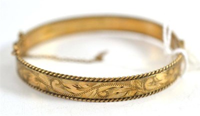 Lot 71 - A 9ct gold engraved bangle