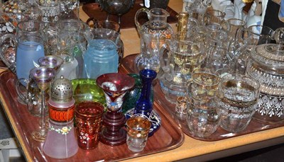 Lot 122 - Three trays including a collection of Victorian clear glass and enamel ewers, stoppers, a...