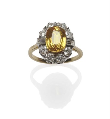 Lot 507 - A Yellow Sapphire and Diamond Ring, the oval mixed cut yellow sapphire in a yellow four claw...