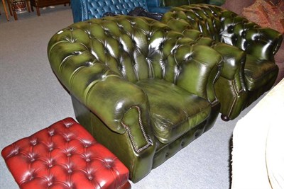 Lot 421 - A pair of modern green button back leather armchairs and a similar footstool in red leather