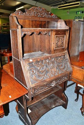 Lot 440 - Carved oak bureau with open bookcase below