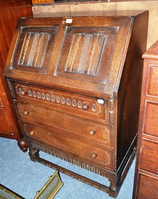 Lot 450 - A reproduction oak linen fold bureau