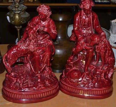 Lot 38 - A pair of large red glazed seated figures feeding dogs
