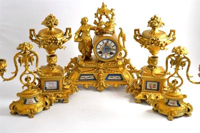 Lot 113 - A gilt metal figural mantel clock, a pair of similar urns on stands and a pair of twin branch...