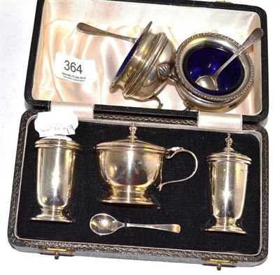 Lot 364 - A cased three piece silver cruet set and two silver salts with blue glass liners and spoons