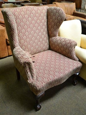 Lot 523 - Early 20th century wing back chair on claw and ball feet