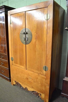 Lot 572 - A Chinese hardwood two door cupboard with carved frieze