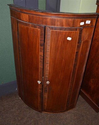 Lot 576 - A 19th century mahogany bow front corner cupboard