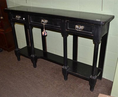 Lot 588 - An ebonised two tier console table with three drawers