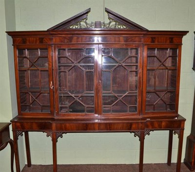 Lot 590 - A mahogany breakfront display cabinet, with astragal glazed doors, raised on associated table...