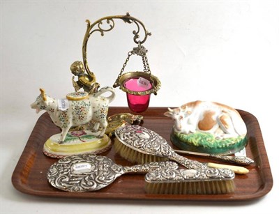 Lot 43 - Cast brass flower holder with cranberry liner, china cow creamer, cow ornament, silver mounted...