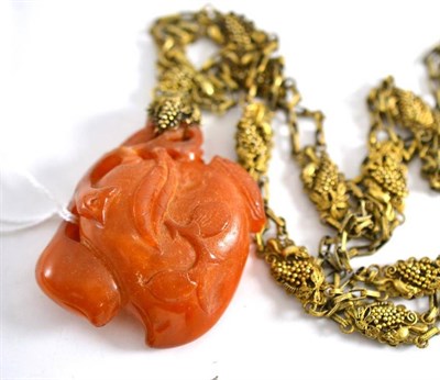 Lot 103 - A Chinese carved amber pendant in the form of a peach, on a gilt necklace