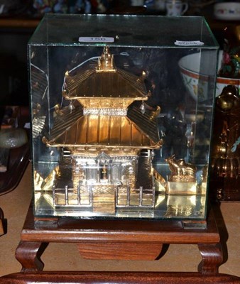 Lot 156 - East gilt and white metal model of a pagoda in a fitted glass case on stand