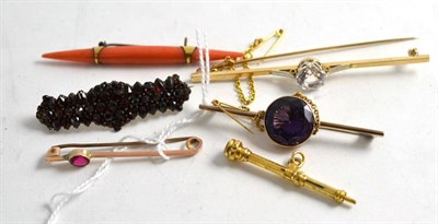 Lot 207 - A coral brooch, three stone set bar brooches, a garnet brooch and a Victorian pencil (6)