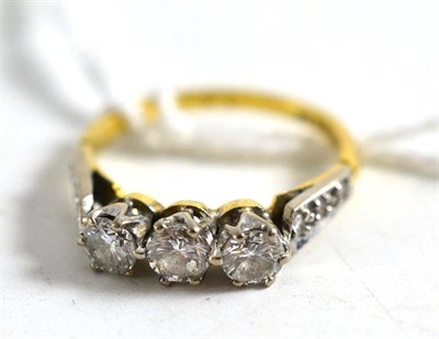 Lot 335 - An 18ct gold diamond three stone ring, with stone set shoulders, total estimated diamond weight...