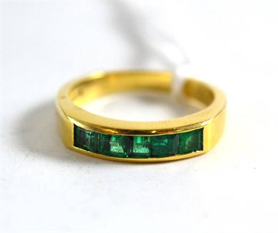 Lot 345 - Gold and emerald half eternity ring