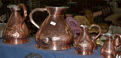 Lot 415 - A Harlequin set of eight copper measuring jugs