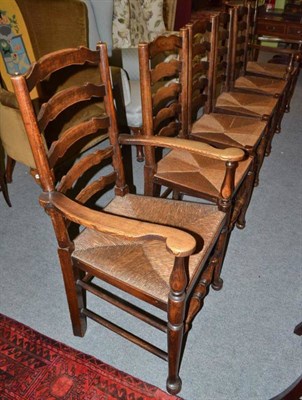 Lot 629 - A set of six ladder back rush seated chairs including two carvers