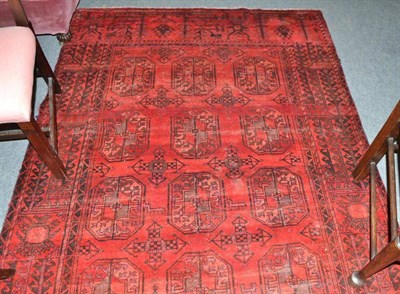 Lot 652 - An Afghan carpet, Afghan Turkestan, the claret field with three rows of elephant foot guls enclosed