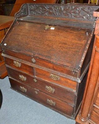 Lot 690 - An 18th century and later oak bureau with carved back rail