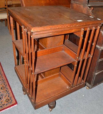 Lot 691 - An Edwardian oak revolving bookcase with Maple & Co retailer label