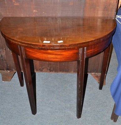 Lot 718 - A mahogany demi-lune fold-over table