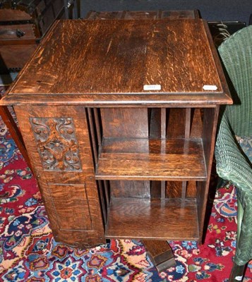 Lot 807 - An oak revolving bookcase with carved panels