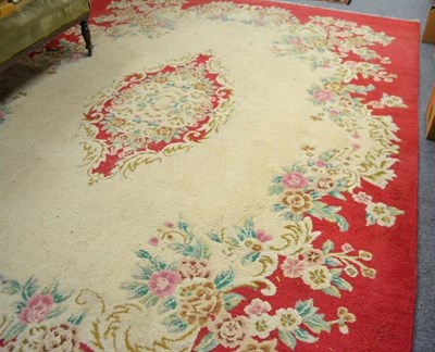 Lot 886 - A large red and beige ground rug