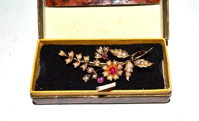 Lot 127 - An Edwardian flower spray brooch set with seed pearls and ruby coloured stones