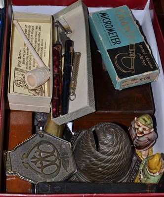 Lot 155 - A box of collectables including a bee skep money box, an early AA car badge, pens, drawing...