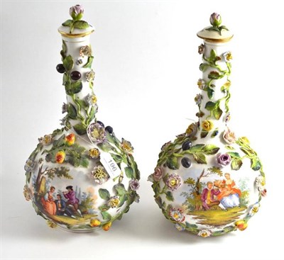 Lot 196 - A pair of Dresden flower-encrusted porcelain bottle vases and covers painted with figures in...