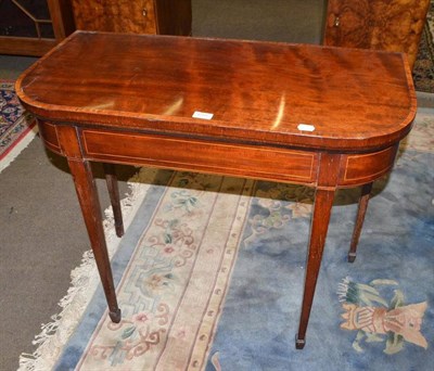 Lot 619 - A 19th century mahogany fold over games table on spade feet with boxwood stringing