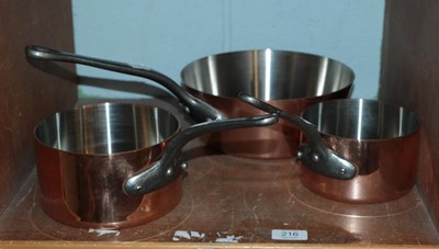 Lot 216 - An assembled set of three graduated saucepans,...