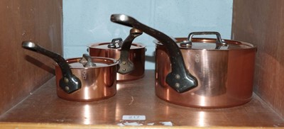Lot 217 - A set of three graduated covered saucepans,...