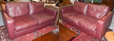 Lot 1373 - A pair of maroon leather three-seater sofas,...