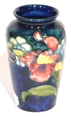 Lot 10 - A Walter Moorcroft Orchid and Spring Flowers Pattern Vase, on a blue ground, impressed...