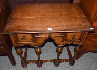 Lot 1275 - An early 20th century oak three drawer low boy...
