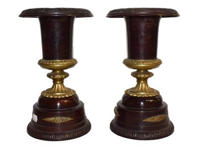 Lot 134 - A pair of patinated and parcel gilt metal urns,...