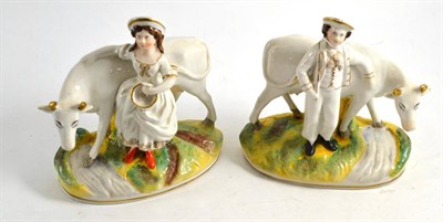 Lot 204 - Pair of Victorian Staffordshire cow and child groups, mainly in white and gold