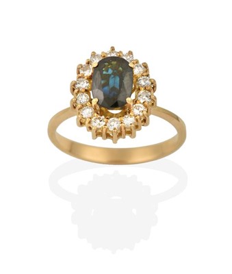 Lot 2293 - A Sapphire and Diamond Cluster Ring, the oval...