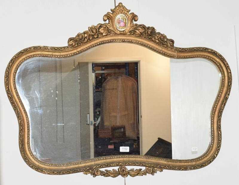 Lot 1192 - A gilt framed mirror surmounted by a painted...