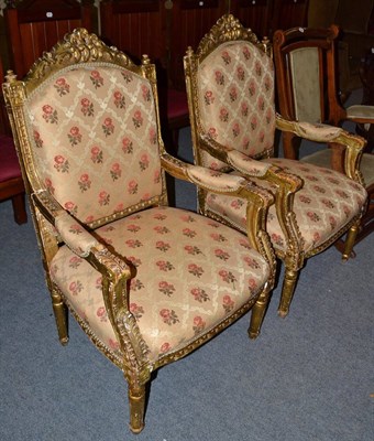 Lot 477 - A pair of gilt French style armchairs with yellow upholstery and a repeating rose motif