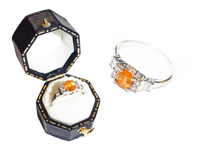 Lot 128 - A yellow/orange sapphire and diamond ring, the...