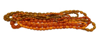 Lot 230 - Two amber bead necklaces; and three amber type...