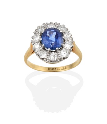 Lot 2342 - A Sapphire and Diamond Cluster Ring, the oval...