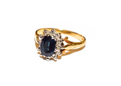 Lot 178 - A sapphire and diamond cluster ring, stamped...